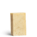 Eczema Ease cleansing soap bar with no packaging. Yellow in colour with exfoliating pieces inside