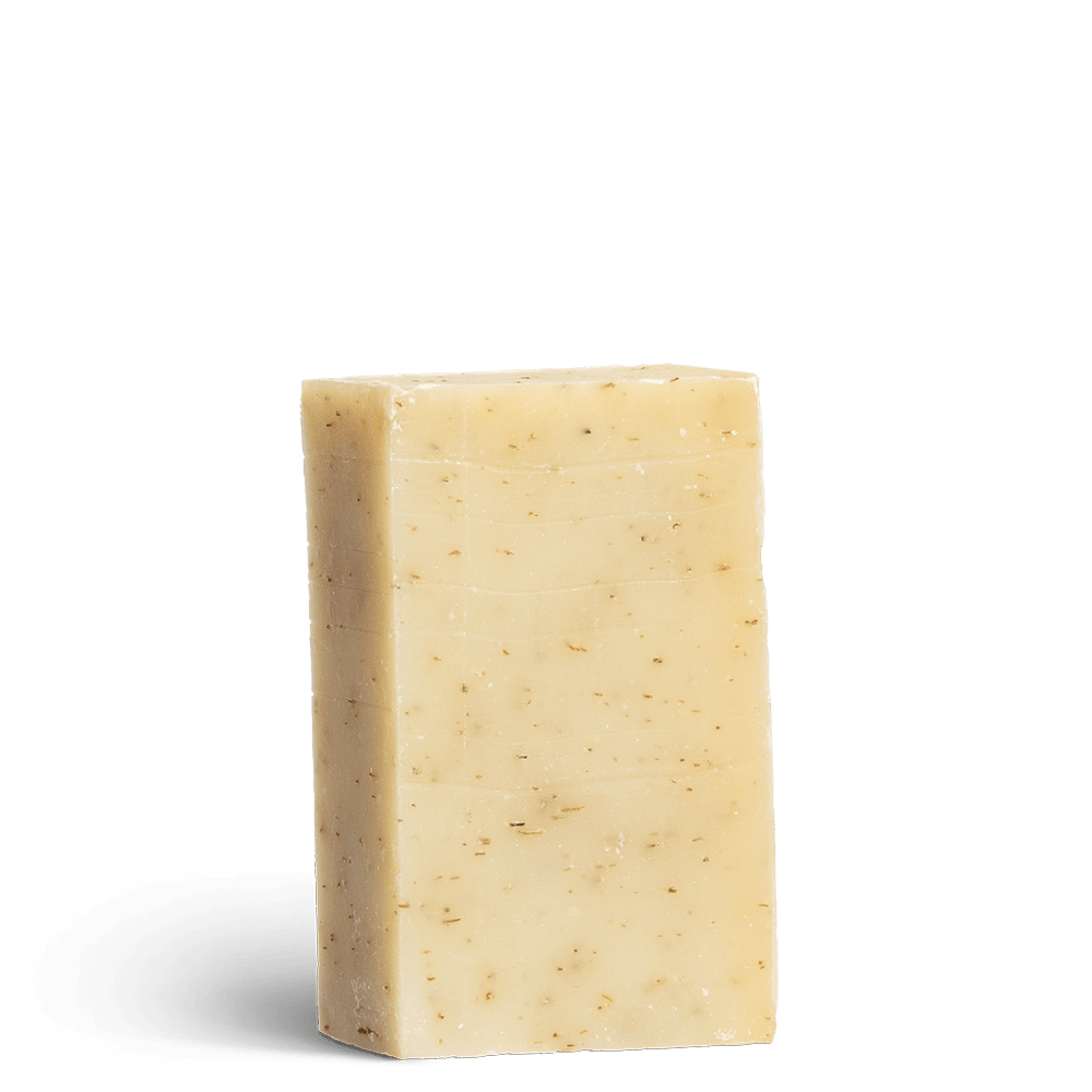 Eczema Ease cleansing soap bar with no packaging. Yellow in colour with exfoliating pieces inside